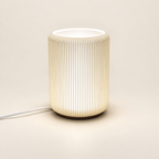 NIMI mini table lamp showing its ribbed shade and dark base on a cream background