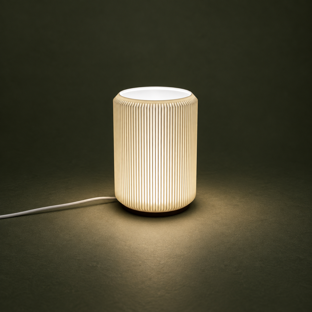 NIMI ribbed mini table lamp with soft warm light against a dark green background