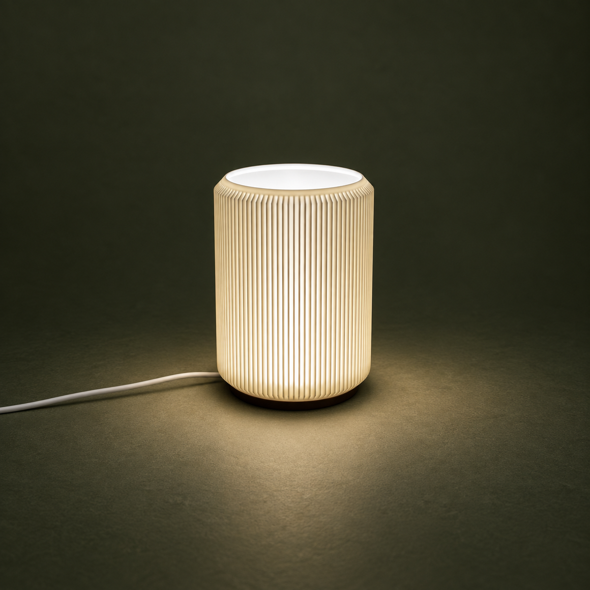 NIMI ribbed mini table lamp with soft warm light against a dark green background