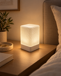 ARQO Table Lamp glowing warm white on a bedside table