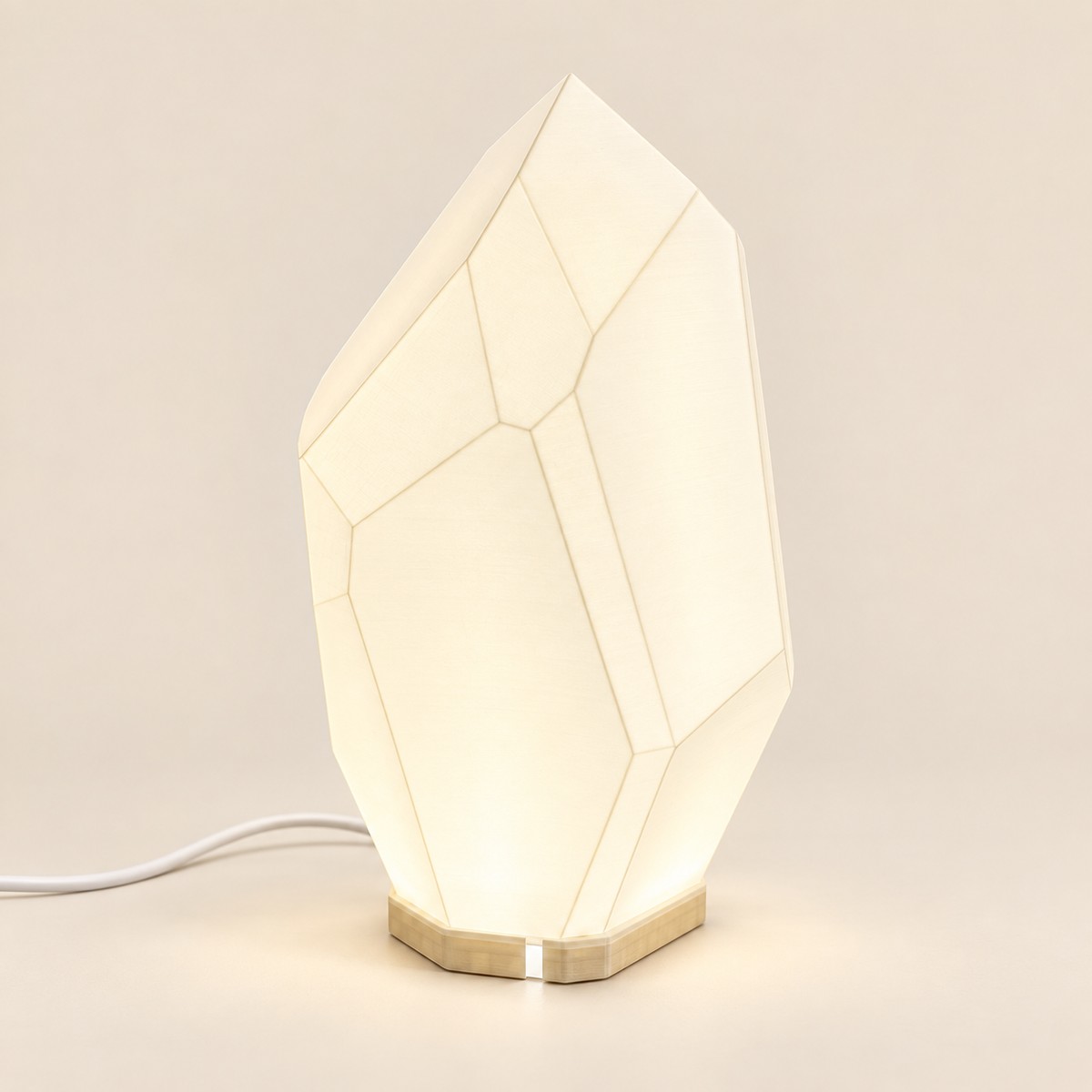 FACET table lamp with a light-toned base on an ivory background